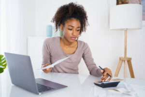 Woman holding paper bill, paying for gas, electricity and rent