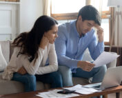 man and woman at the coffee table looking over papers