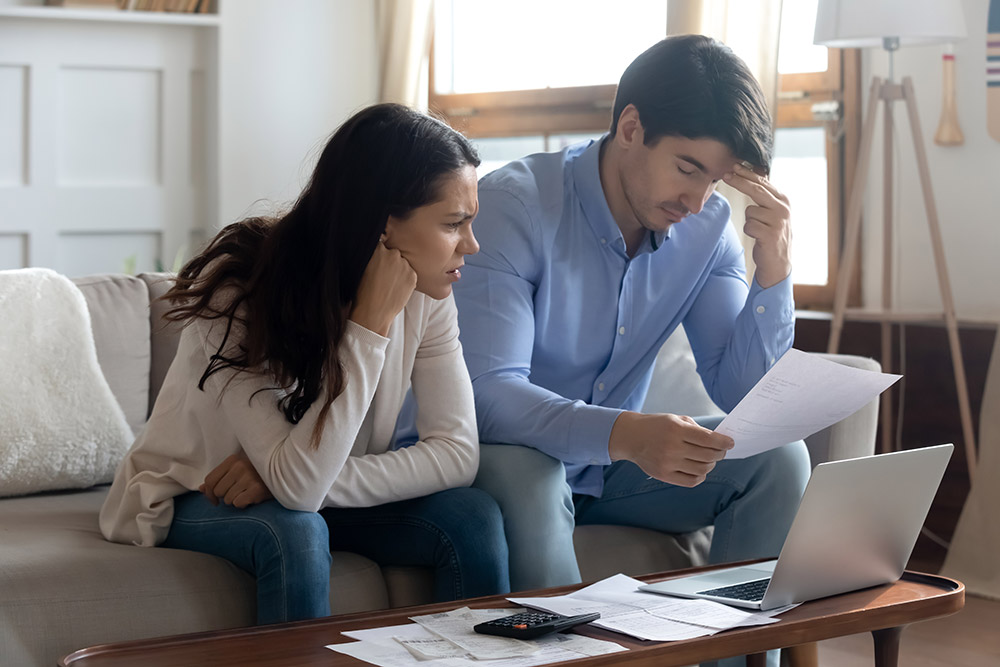 man and woman at the coffee table looking over papers